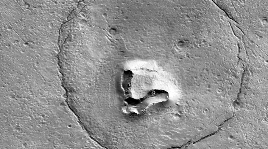 Орбитальный аппарат NASA Mars Reconnaissance Orbiter сфотографировал фрагмент рельефа на Марсе, напоминающий морду медведя, сообщает CNET.